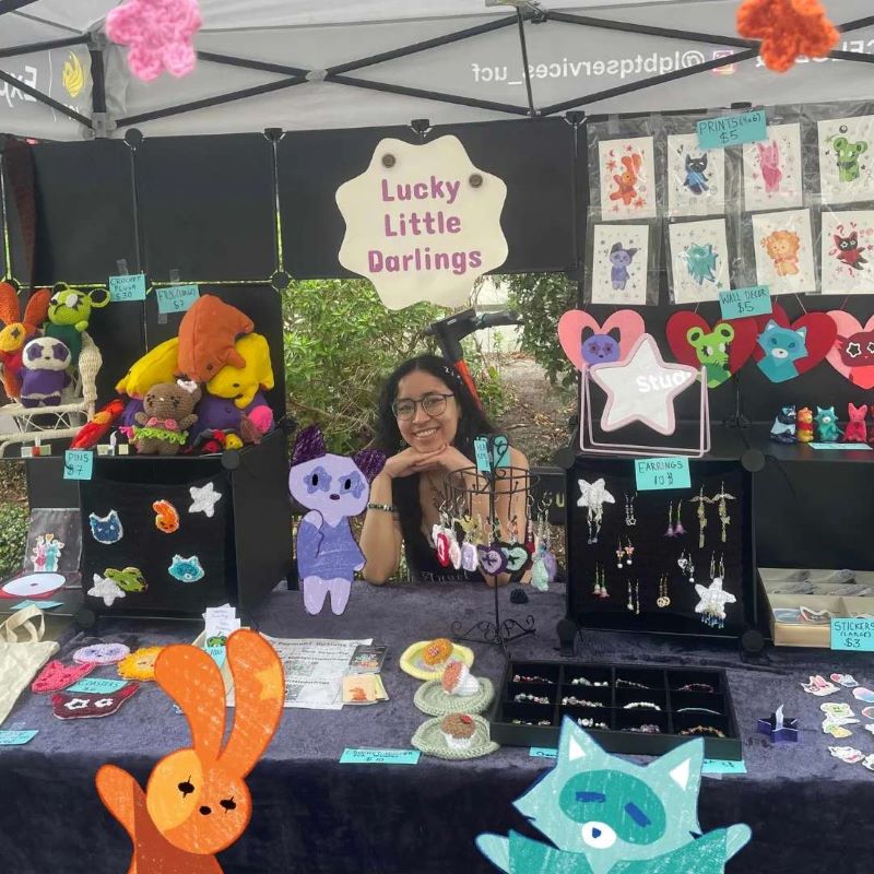 Emilia at a vendor table with her artwork